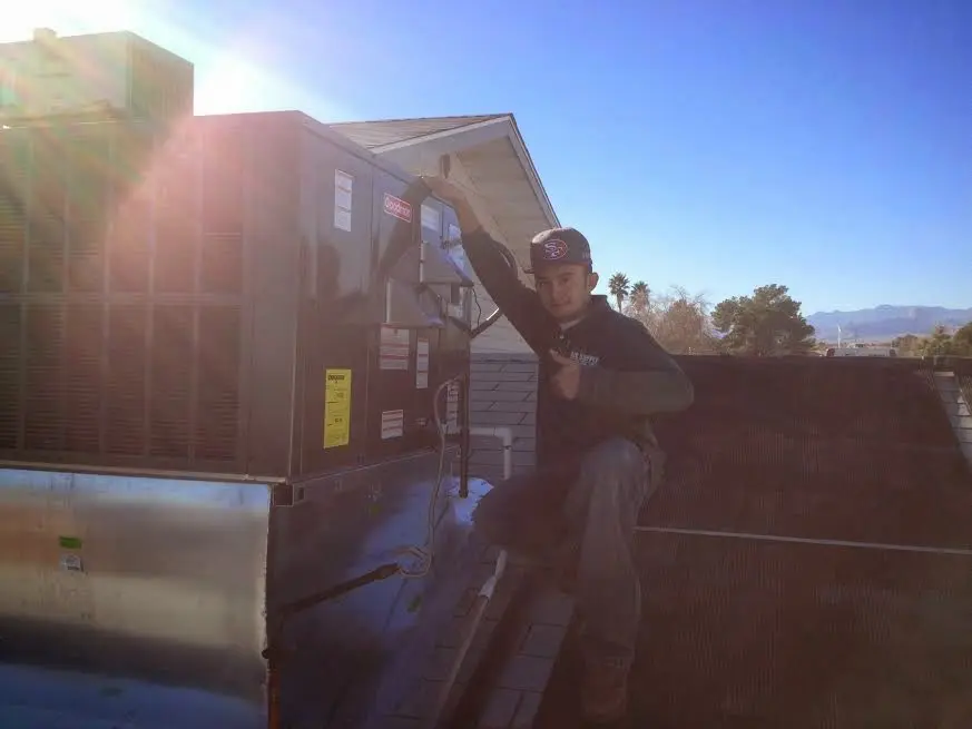 HVAC technician performing AC Tune-Up on a rooftop unit in River Grove